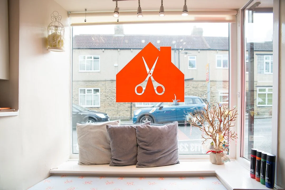 The salon's window seat and orange cottage and scissors window design